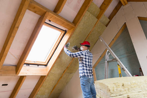 Man installing thermal roof insulation layer - using mineral wool panels. Attic renovation and insulation concept